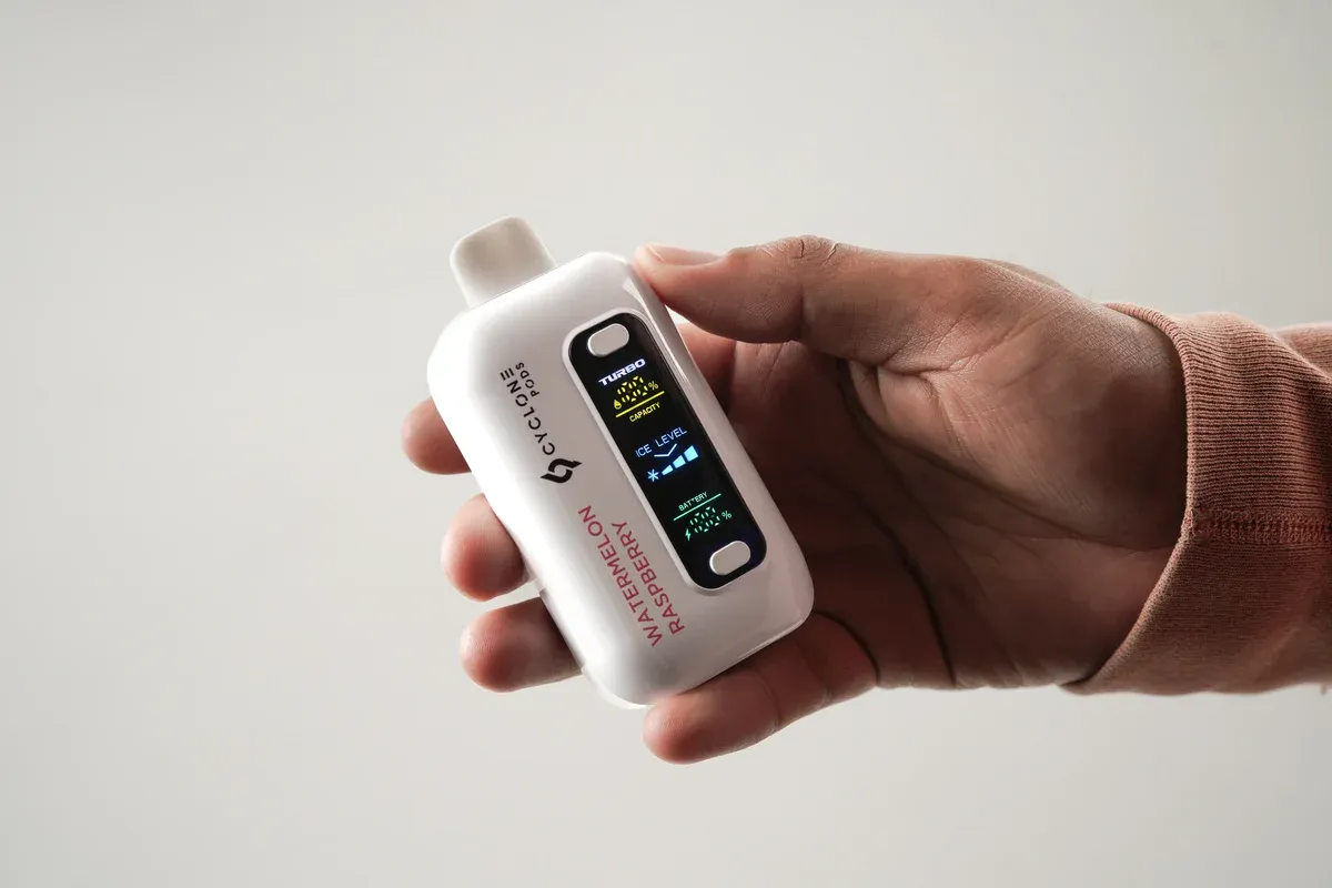Person holding Cyclone Pods Gust Pro showing the screen display with battery and liquid level